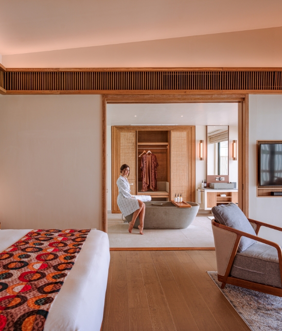 Sunset Water Villa bedroom with a guest at Kuda Villingili Resort Maldives