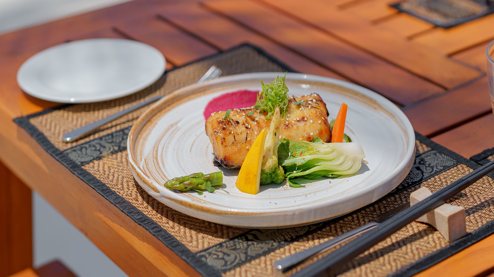 Grilled fish with fresh vegetables served on a plate at Kuda Villingili Maldives restaurant