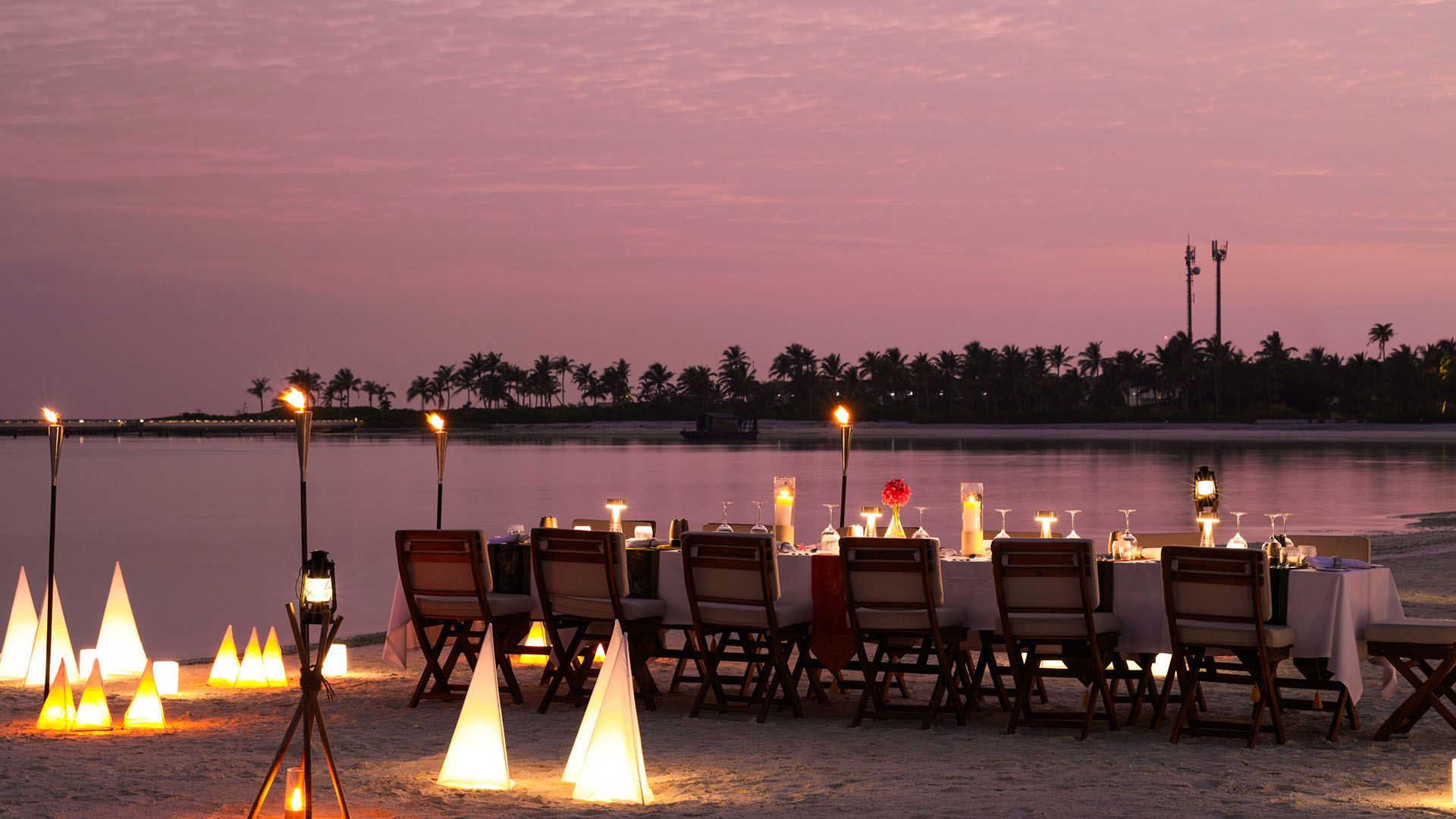 Romantic beach table setting with soft lights at Kuda Villingili Maldives