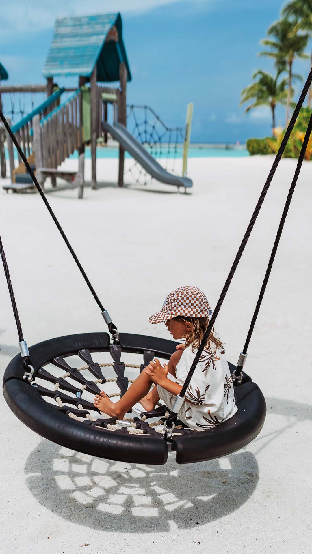 Kid enjoying a swing at Kuda Villingili Maldives kid's outdoor playground