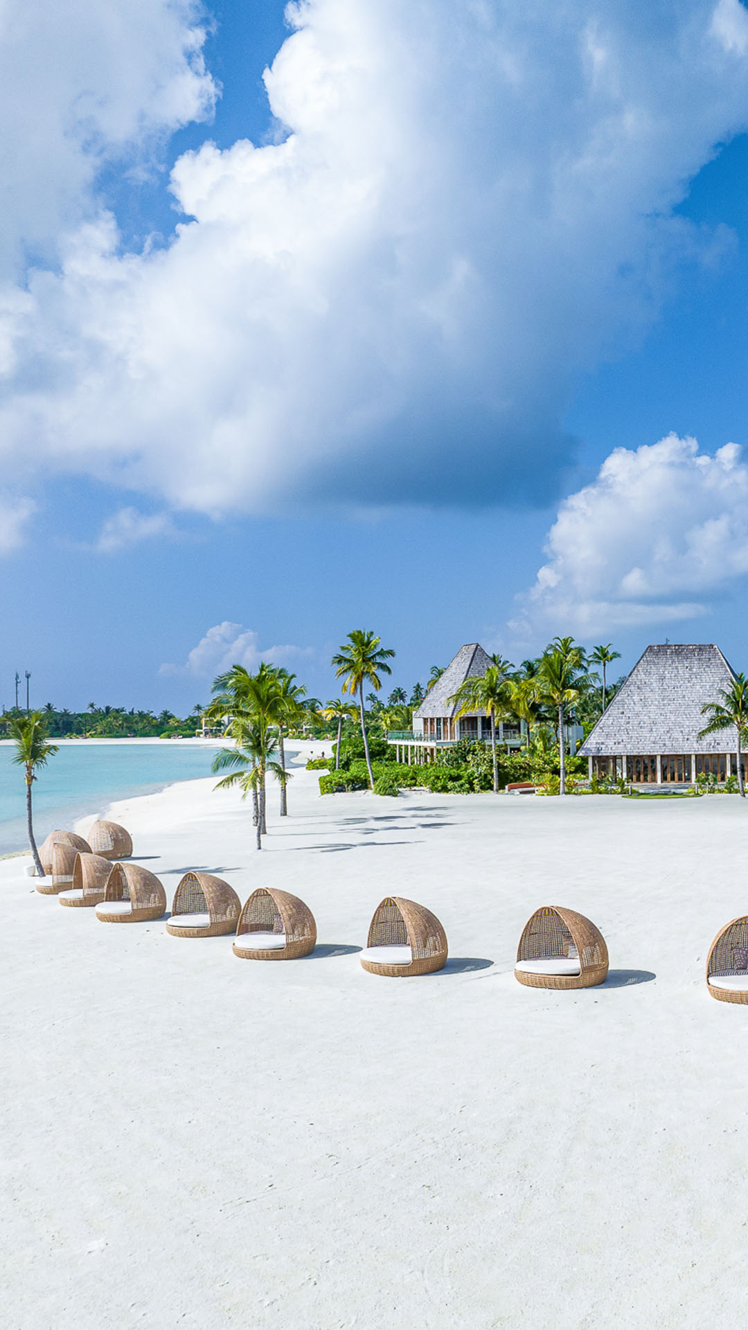Beach view with birdcage beds and outdoor lounge at Kuda Villingili Maldives