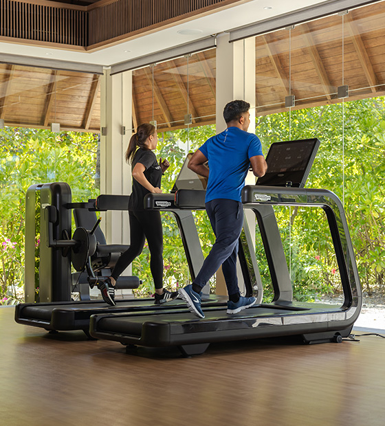 Couple exercising on treadmills at Kuda Villingili Maldives gym