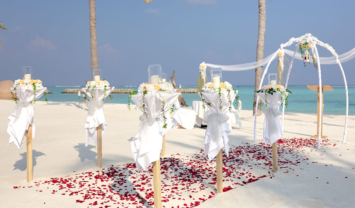 Beachside wedding setup with floral decorations at Kuda Villingili Maldives