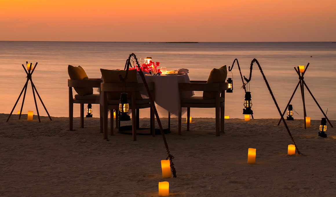 Romantic beach table setting with soft lights at Kuda Villingili Maldives