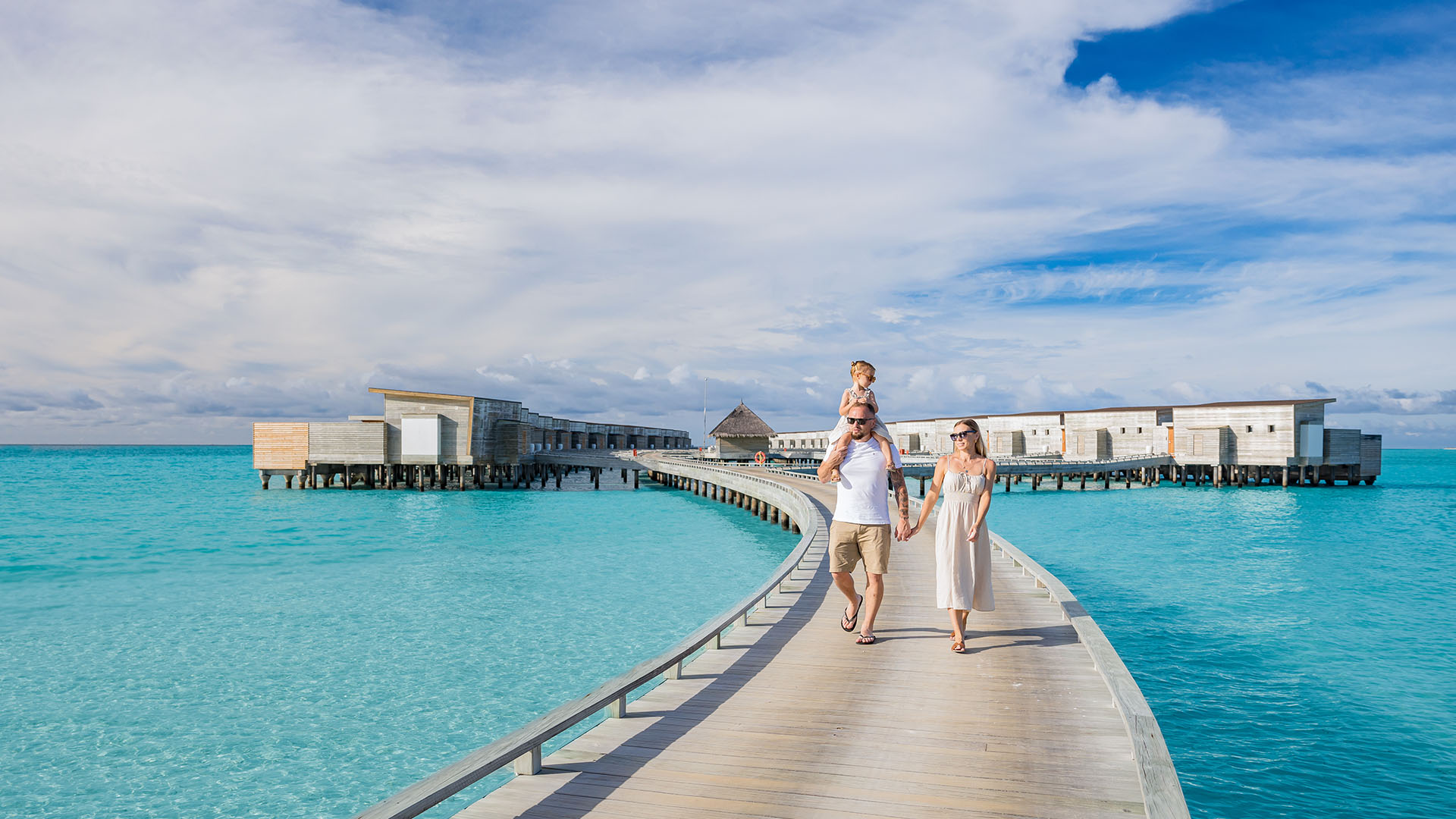 Family walking along a pier at Kuda Villingili surrounded by stunning views