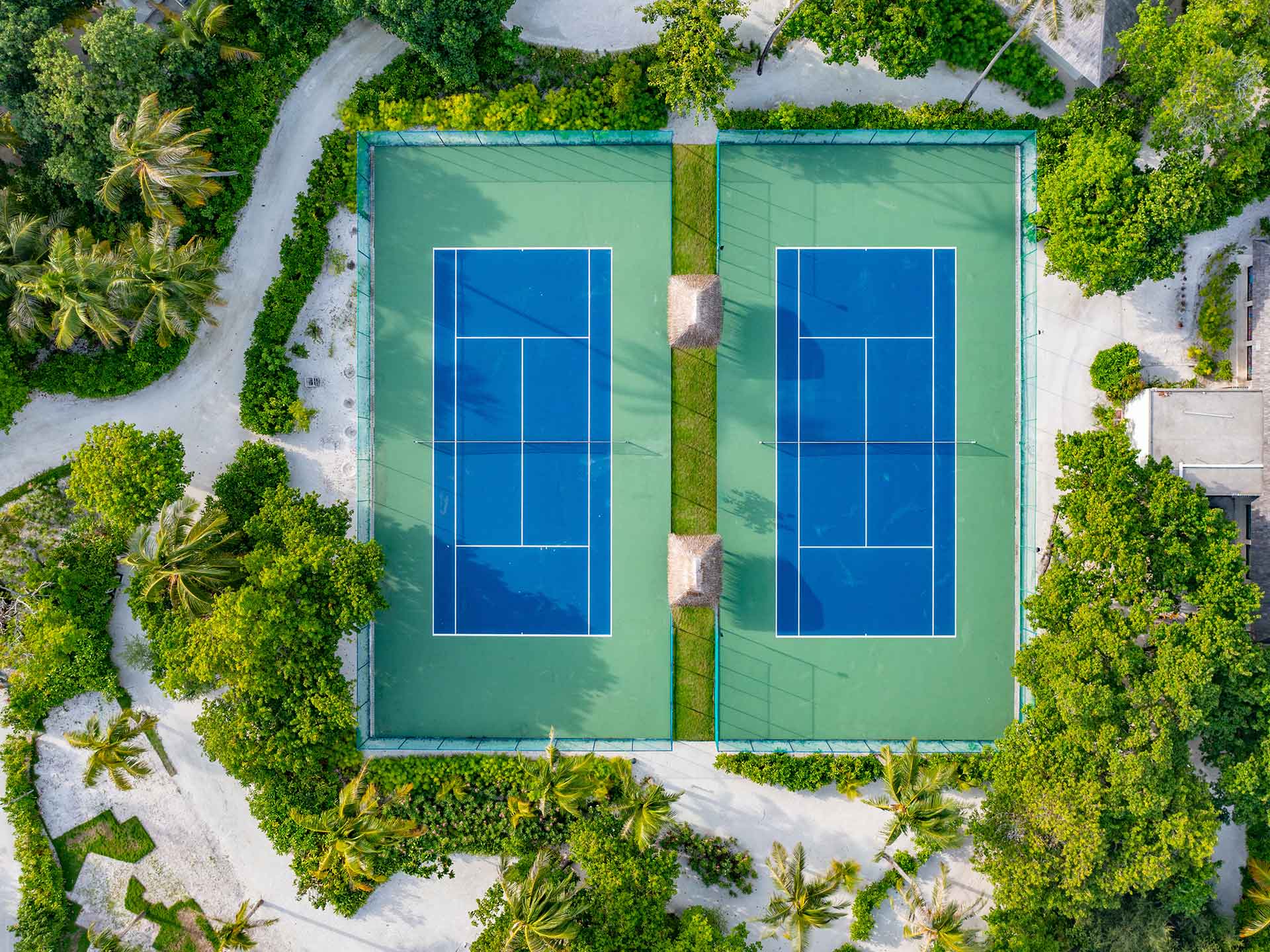 Aerial view of the tennis court surrounded by green landscapes at Kuda Villingili